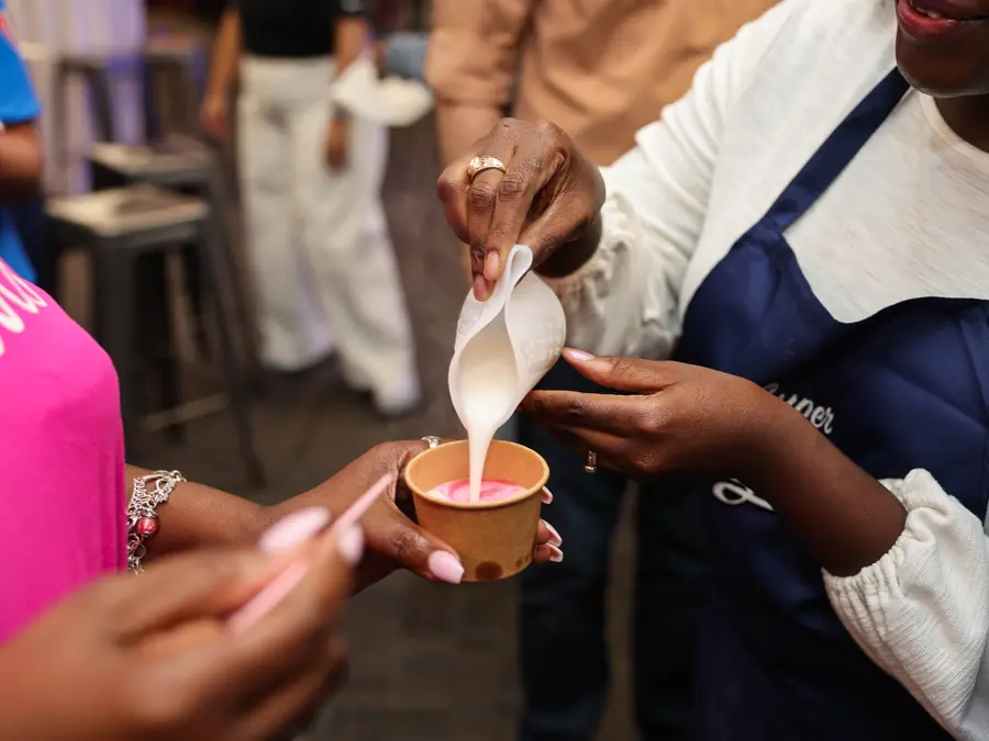 Priscilla Mensah helping a participant pour soap during a workshop.