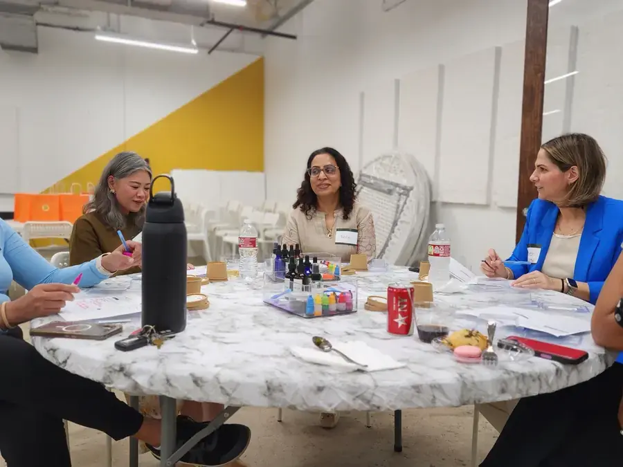 Process Image: Gather Houston workplace team gathered around a prepared soapmaking workshop table