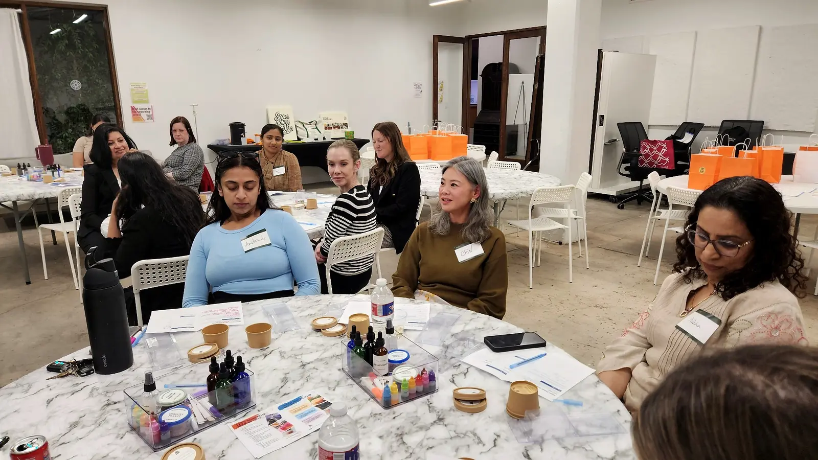 Feature Image Women seated with prepared materials during a Houston community-building soapmaking workshop