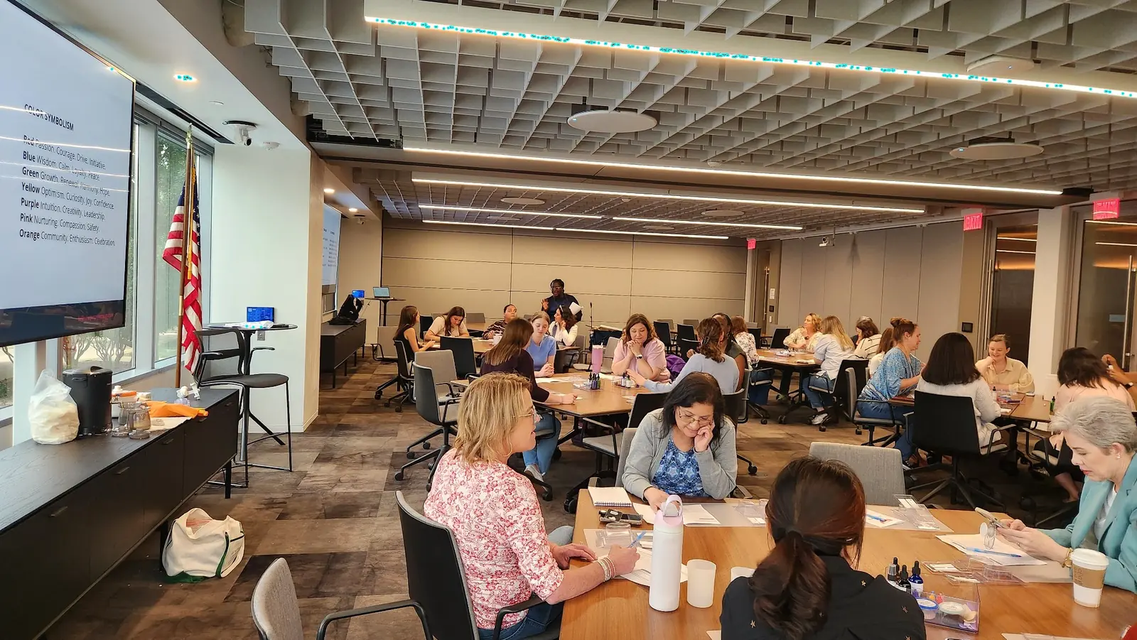Evidence Image: A facilitated format that can hold a full room without losing the table-level experience. Large Houston workplace group seated at tables during a Storytelling Through Soapmaking team-building workshop